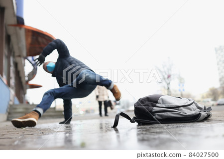 Male person get injury after falling on slippery ground in winter 84027500