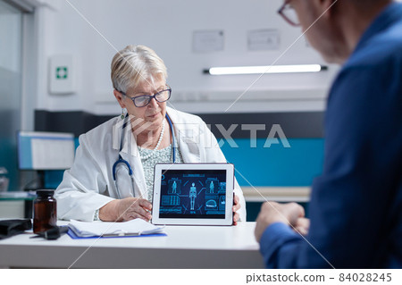 Doctor analyzing tablet with illustration of human body analysis with old man 84028245