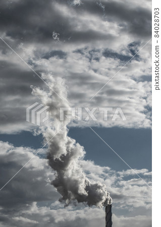 The chimney in deep blue heavy sky of a thermal power plant, the smoke extracted in the production process from pipe. Environment. Pollution. 84028703