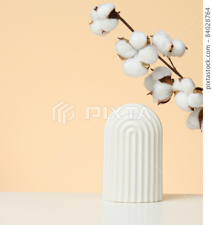 podium with white flower cotton and arches to showcase cosmetics, products and other goods, beige background podium with white flower cotton and arches to showcase cosmetics, products and other goods, beige background 84028764