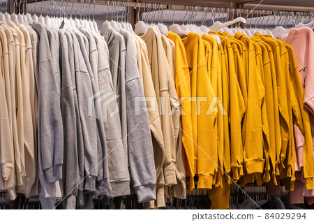 Stylish fashionable clothes on hangers in a store. Stylish fashionable clothes on hangers in a store. 84029294