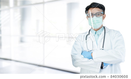 Asian doctor wearing face shield and PPE suit new normal to check patient protect safety infection Covid-19 Coronavirus outbreak at quarantine nursing hospital; for header banner 84030608