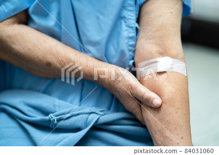 Asian senior or elderly old lady woman patient show cotton wool stop bleeding, after blood drawing testing for annually physical health check up to check cholesterol, blood pressure, and sugar level. 84031060