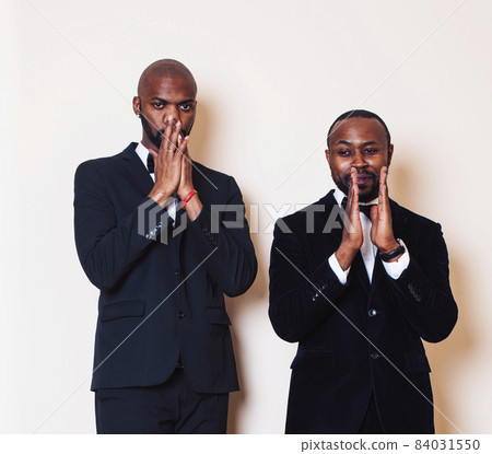 two afro-american businessmen in black suits emotional posing, gesturing, smiling. wearing bow-ties two afro-american businessmen in black suits emotional posing, gesturing, smiling. wearing bow-ties 84031550