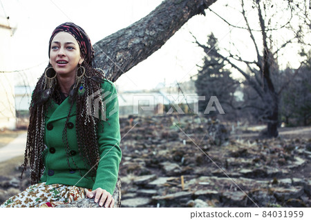 young adorable pretty girl with pigtails hairstyle smiling outside among trees 84031959