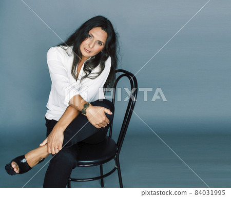 pretty brunette confident mature woman sitting on chair in studio, lifestyle people concept pretty brunette confident mature woman sitting on chair in studio, lifestyle people concept 84031995