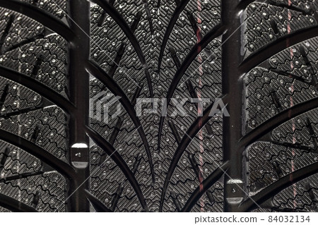 Clean car tyres spinning against dark background 84032134