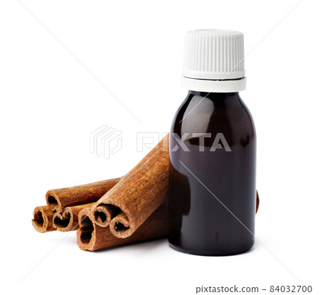 Aromatic cinnamon sticks and essential oil on white background 84032700