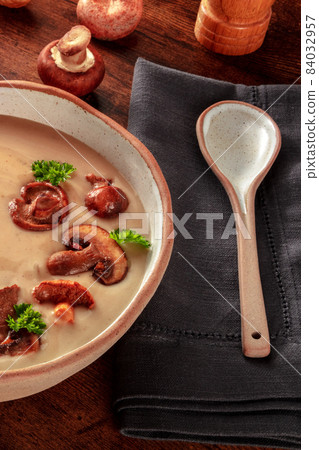 Mushroom pureed soup with a spoon, on a rustic wooden background 84032957