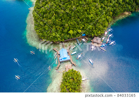 Drone photo of a turquoise blue sea and island with boat in Siargao, Philippines. 84033165