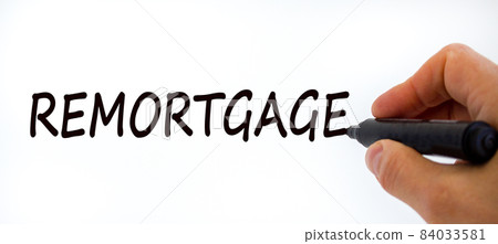 Remortgage symbol. Businessman writing the word 'remortgage', isolated on beautiful white background. Business and remortgage concept, copy space. Remortgage symbol. Businessman writing the word 'remortgage', isolated on beautiful white background. Business and remortgage concept, copy space. 84033581