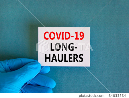 COVID-19 long-haulers covid symptoms symbol. White card with words Covid-19 long-haulers. Doctor hand, blue background, copy space. Medical, COVID-19 long-haulers covid symptoms concept. COVID-19 long-haulers covid symptoms symbol. White card with words Covid-19 long-haulers. Doctor hand, blue background, copy space. Medical, COVID-19 long-haulers covid symptoms concept. 84033584