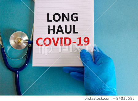 COVID-19 long-haul covid symptoms symbol. White card with words Long haul covid-19. Doctor hand, stethoscope, beautiful blue background copy space. Medical, COVID-19 long-haul covid symptoms concept. COVID-19 long-haul covid symptoms symbol. White card with words Long haul covid-19. Doctor hand, stethoscope, beautiful blue background copy space. Medical, COVID-19 long-haul covid symptoms concept. 84033585