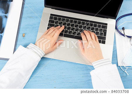 Top view of doctor hands typing at laptop 84033708
