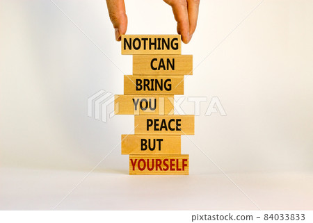 Concept of building success foundation. Businessman hand. Wooden blocks with words nothing can bring you peace but yourself. Beautiful white background, copy space. Business and motivational concept. 84033833