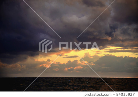 Seashore sky orange tones clouds and sea waves beautiful nature bright sunset Seashore sky orange tones clouds and sea waves beautiful nature bright sunset 84033927