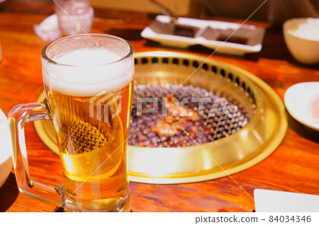 Drink beer while eating grilled meat 84034346