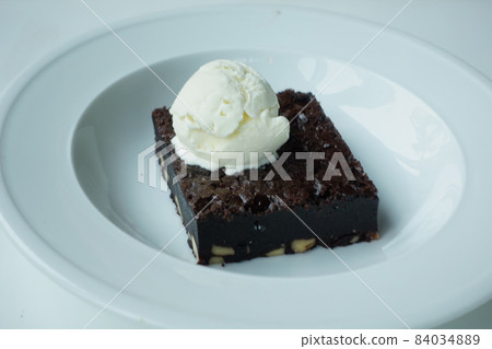 slice of brownie and ice cream on plate on table  84034889
