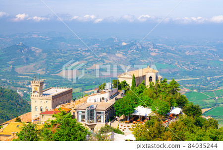 Aerial top panoramic view of Basilica, Palazzo Pubblico palace and landscape with valley Aerial top panoramic view of Basilica, Palazzo Pubblico palace and landscape with valley 84035244