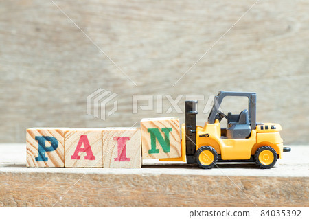 Toy forklift hold letter block n to complete word pain on wood background 84035392