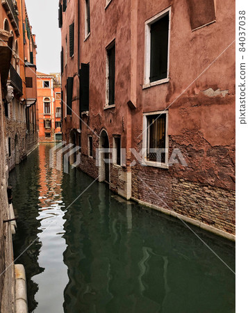 narrow canals of Venice surrounded by buildings in Italy 84037038