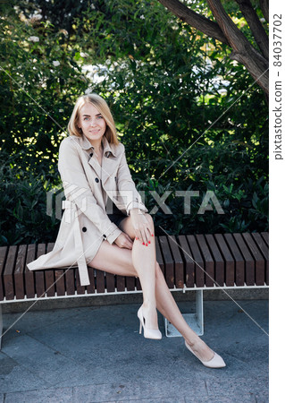 beautiful blonde woman in an autumn cloak on the street 84037702