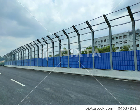 SELANGOR, MALAYSIA - JULY 5, 2020: Noise barriers are installed along the vehicle lane bordering the residence to prevent noise pollution to the surrounding locals. 84037851
