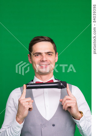 The entertainer. Young elegant talking man holding microphone, Isolated in studio. The entertainer. Young elegant talking man holding microphone, Isolated in studio. 84039398