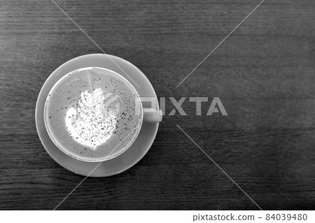 Black and white. Big Coffee cup with milk on the wooden table. cappuccino or latte drink, cup of coffee on table flat lay view. Cup of cafe au lait. Milk paintings. Hot Coffee in a blue mug Black and white. Big Coffee cup with milk on the wooden table. cappuccino or latte drink, cup of coffee on table flat lay view. Cup of cafe au lait. Milk paintings. Hot Coffee in a blue mug 84039480