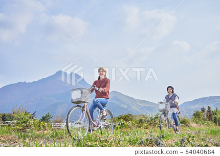 Young women and friends walking around Yufuin by bicycle 84040684
