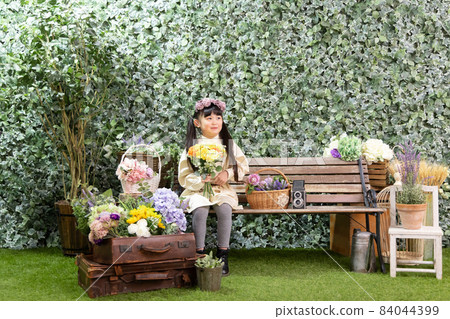 一個女孩坐在長椅上 一個女孩坐在長椅上 84044399