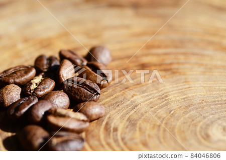 Close up of coffee beans on the grain of wood 84046806