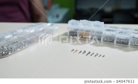 Bolts for repairing eyeglass frames on a white background. 84047611