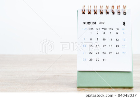 August 2022 desk calendar on wooden table. 84048037