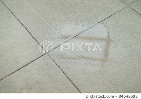 Water drips onto the tiled floor. 84048698