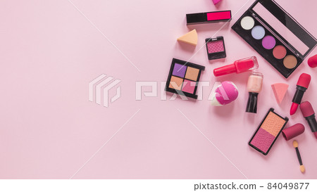 different cosmetics types scattered pink table. High quality beautiful photo concept 84049877
