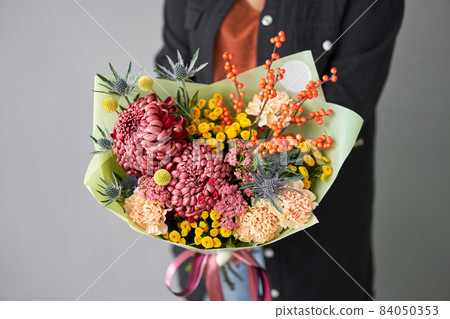 Beautiful bouquet of mixed flowers in woman hand. Handsome fresh bouquet. Small flower shop and Flowers delivery. Beautiful bouquet of mixed flowers in woman hand. Handsome fresh bouquet. Small flower shop and Flowers delivery. 84050353