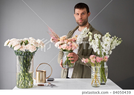 Male florist Step by step installation of flowers in a vase. Flowers bunch, set for home. Fresh cut flowers for decoration home. European floral shop. Delivery fresh cut flower. 84050439