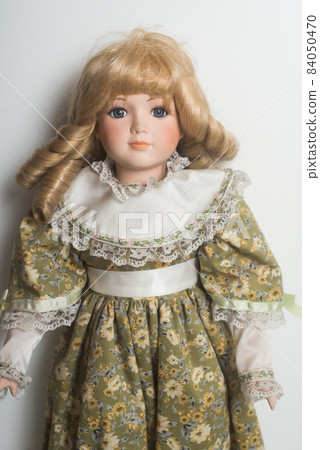 Portrait of vintage dolls wearing a green medieval dress on white background Portrait of vintage dolls wearing a green medieval dress on white background 84050470