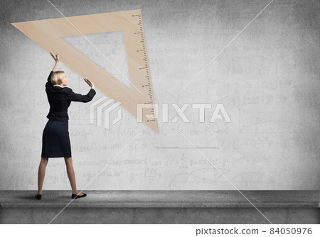 Woman in business suit holding big ruler 84050976