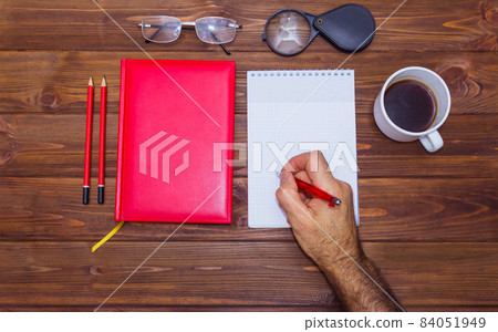 note book and pencil with cup coffee on wooden table 84051949