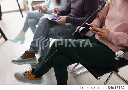 People sitting in line and surfing gadgets 84052182