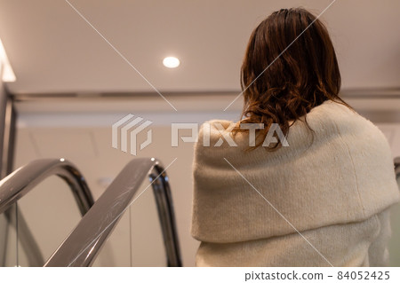 Female climbing an escalator An escalator 84052425
