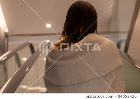 Female climbing an escalator An escalator Female climbing an escalator An escalator 84052426
