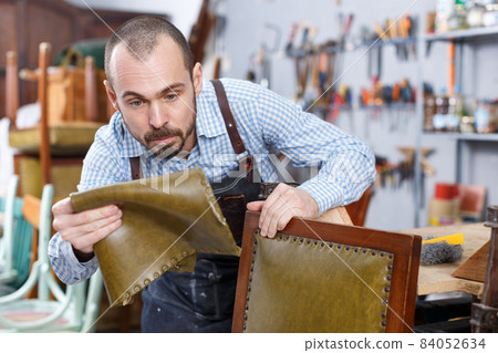 Restorer in process of renovation vintage armchair 84052634
