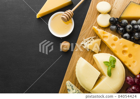 flat lay mix gourmet cheese grapes cutting board with honey. High quality beautiful photo concept 84054424