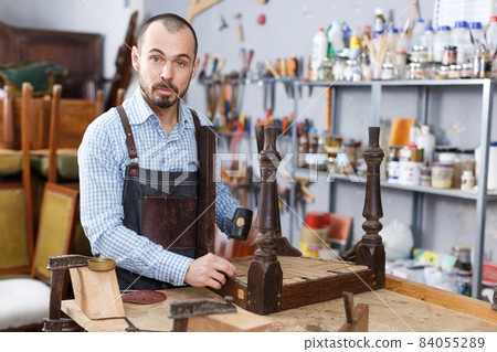 Craftsman using carpentry tools for restoration Craftsman using carpentry tools for restoration 84055289