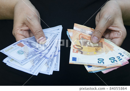 Euro and dollar banknotes in hands. Economy concept, currency exchange Euro and dollar banknotes in hands. Economy concept, currency exchange 84055864