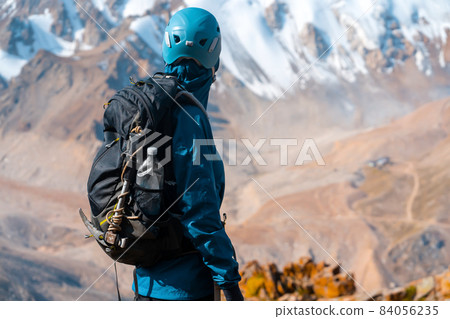 Traveler looks at beautiful view with snowy mountains. Traveler looks at beautiful view with snowy mountains. 84056235