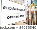 OPENING SOON text with thai language with the same meaning on the Billboard in front of beauty and spa in department store 84056540